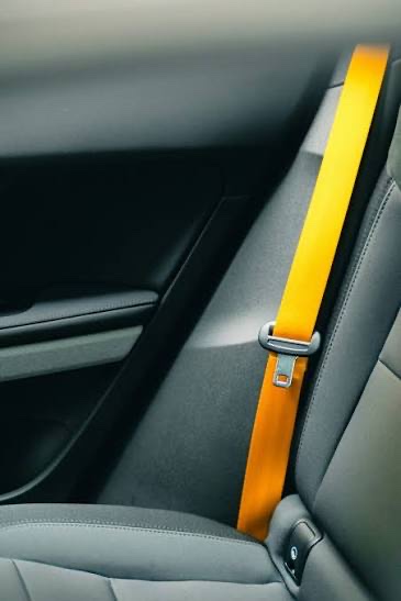 An orange seatbelt running diagonally across a grey vehicle interior