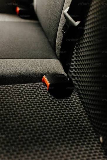 Seatbelt buckle stalks standing upright between the cushions of a rear vehicle bench seat